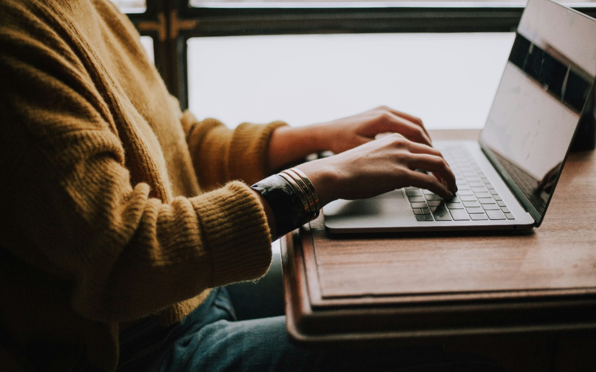 Women typing on laptop at table